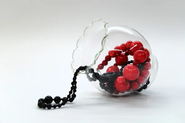 Perles rouges et noires dans un bol en verre — Photo