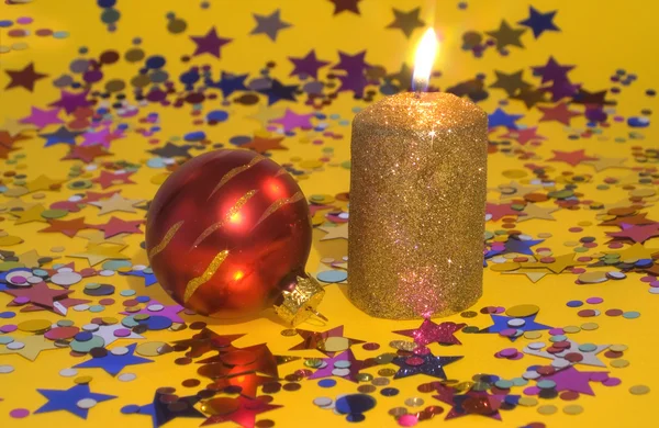 Золотая свеча и красный стеклянный шар — стоковое фото
