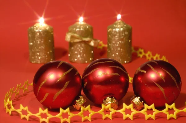 Velas de ouro e bolas de vidro vermelho — Fotografia de Stock