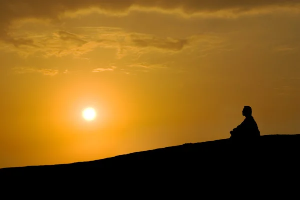 Meditation unter Sonnenuntergang lizenzfreie Stockbilder