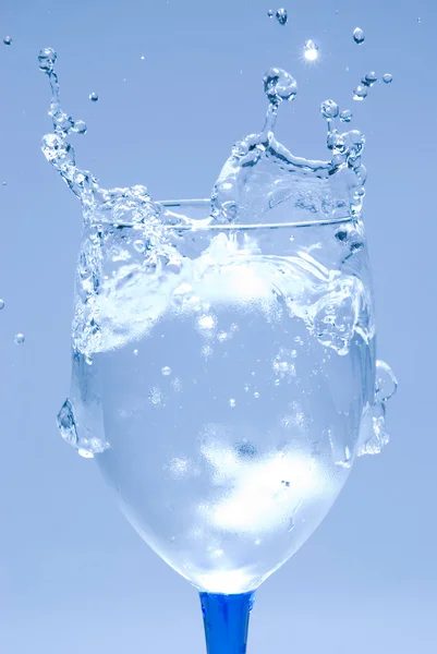 Gelo salpicando água em vidro — Fotografia de Stock