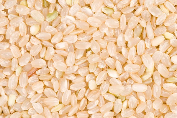 Brown rice as background — Stock Photo, Image
