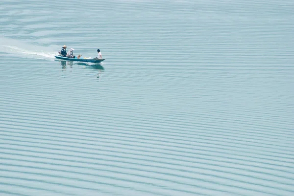 Човен проходить через мирне озеро — стокове фото