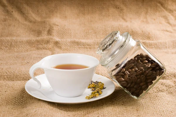 Stock image Tea and glass coffee jar on burlap