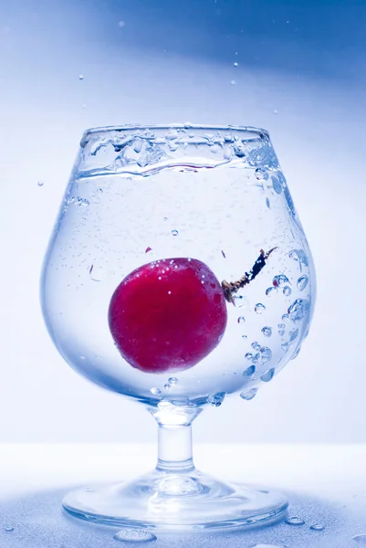 Zmrazený pohyb hroznů a sklenici vody — Stock fotografie