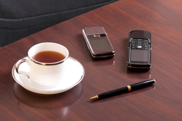 stock image Tea, pen and two cellulars
