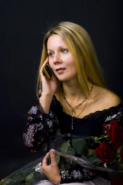 Жінка з трояндами і телефоном — стокове фото