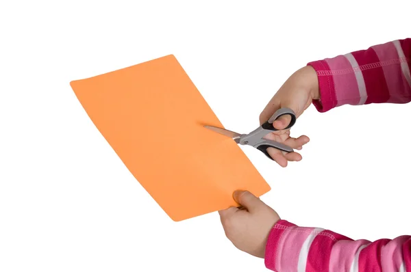 Barnet händer skära ett papper med en sciss Stockfoto