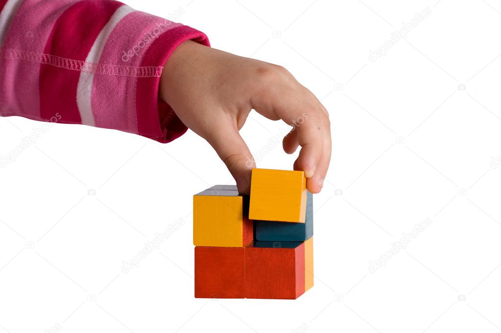 Child hand make a cube of blocks