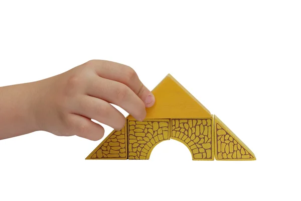 Kinderhand bastelt ein Gebäude aus Bausteinen — Stockfoto