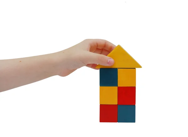 Kinderhand bastelt ein Gebäude aus Bausteinen — Stockfoto