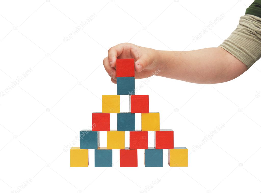 Child hand make a building of blocks