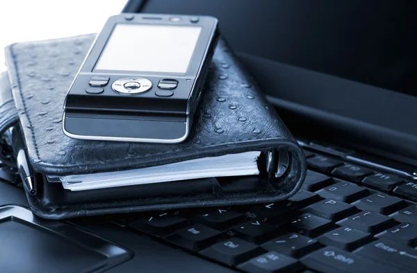Organizer and mobile phone on laptop — Stock Photo, Image