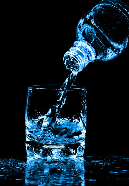 Vatten stänk från flaska i glas jag — Stockfoto