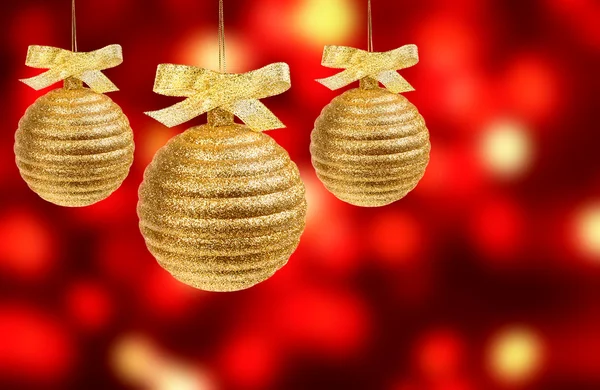 Three golden balls on red background — Stock Photo, Image