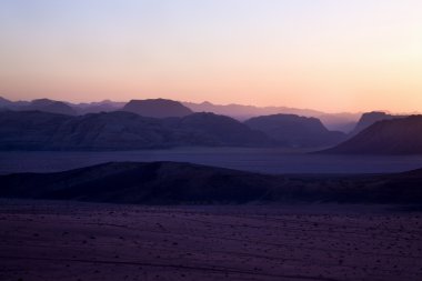 Hills in desert during sunset clipart