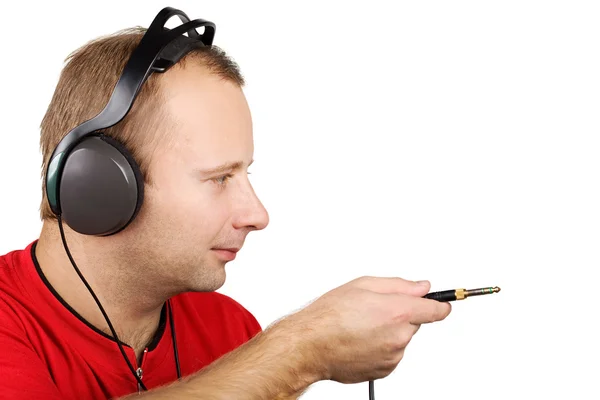 Young man in headphones holding jackplug — Stock Photo, Image