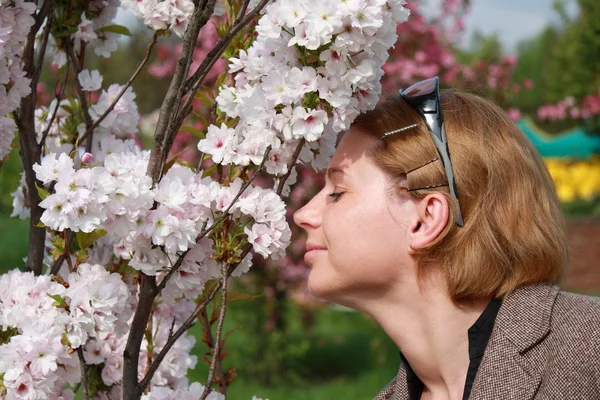 Mulher cheirando flores da primavera ao ar livre — Fotografia de Stock