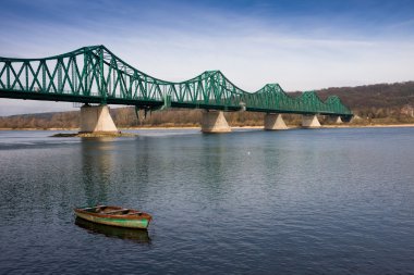 Old boat on vistula river under a bridge clipart