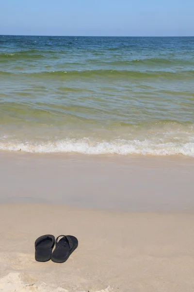 Czarne sandały na plaży — Zdjęcie stockowe