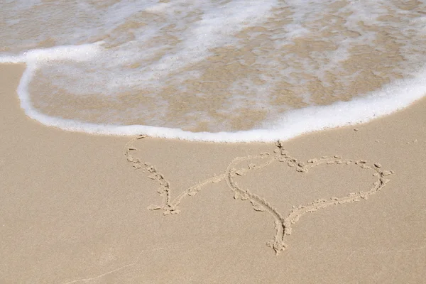 Deux coeurs dessinés sur une plage — Photo