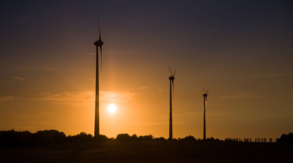 Wind turbines over sunset