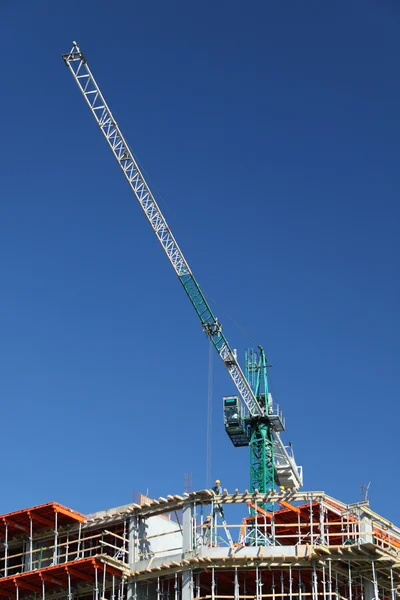Stavební jeřáb proti modré obloze — Stock fotografie