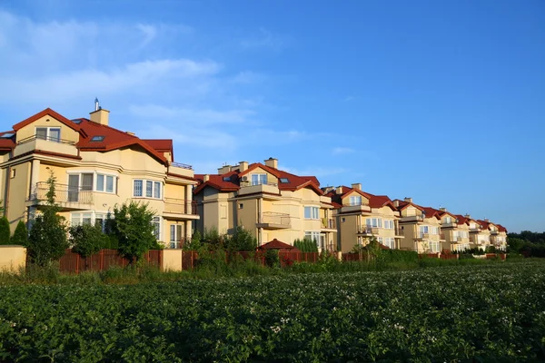Reihe ähnlicher Häuser über blauem Himmel — Stockfoto