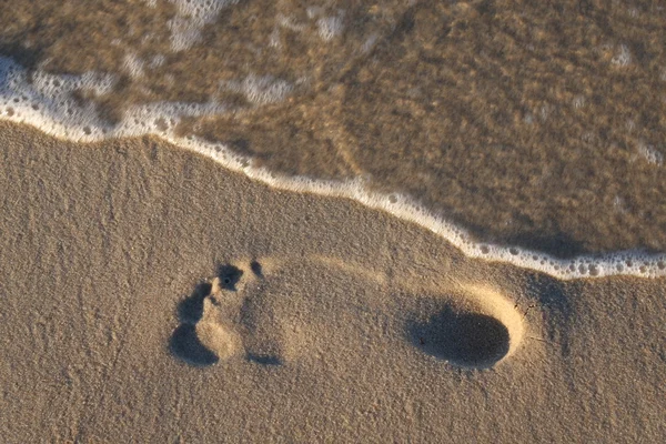Footrpint na plaży, blured wody — Zdjęcie stockowe