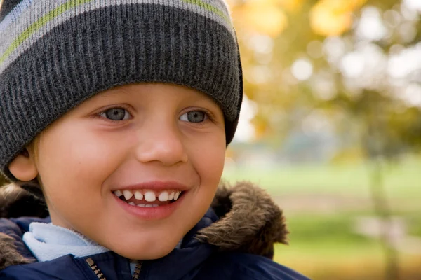 Boy smiling in autumn scenery — Stock Photo, Image