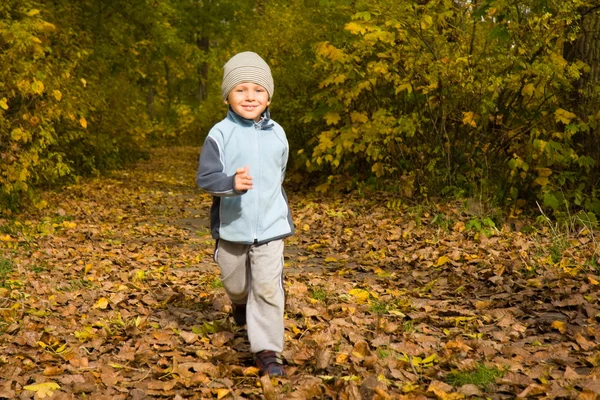 Junge läuft in Herbstkulisse — Stockfoto