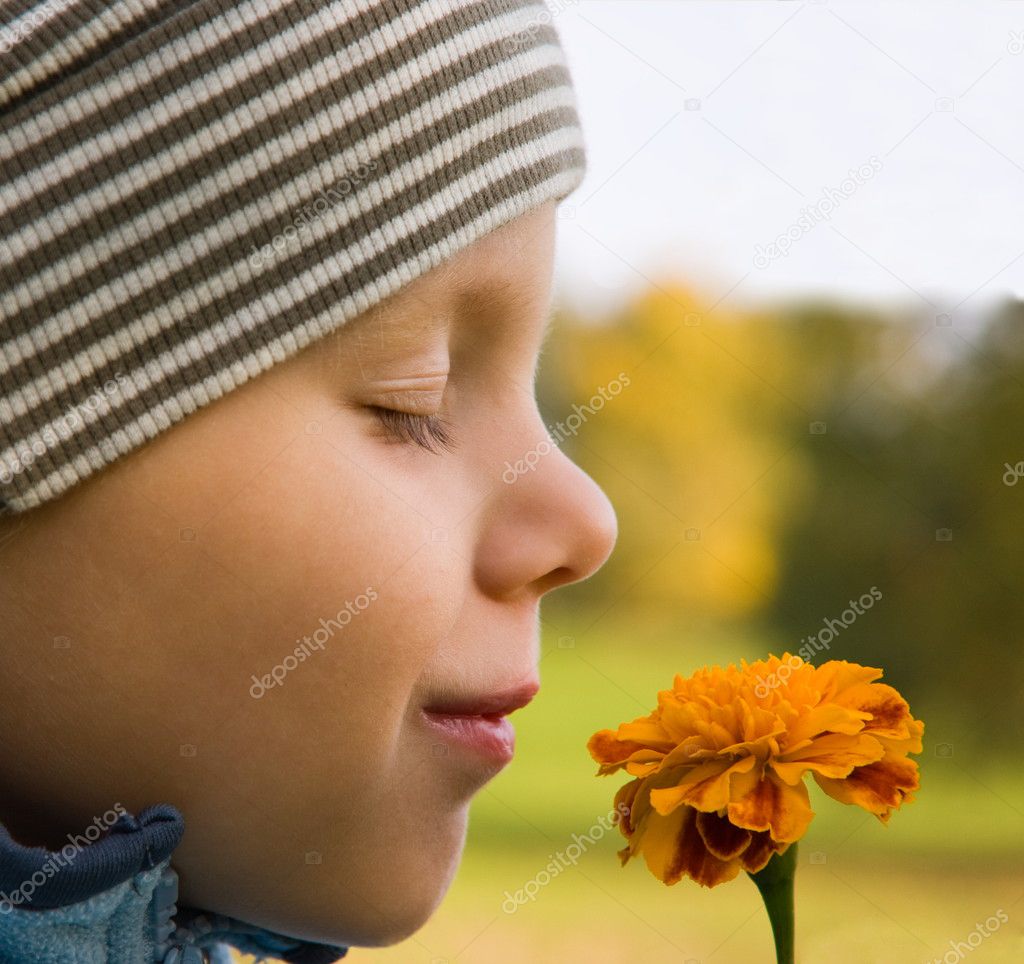 Boy smelling flower in autumn