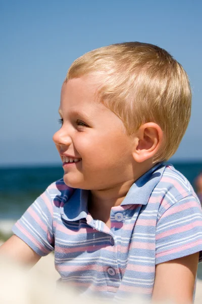 Menino pequeno sorrindo na praia — Fotografia de Stock