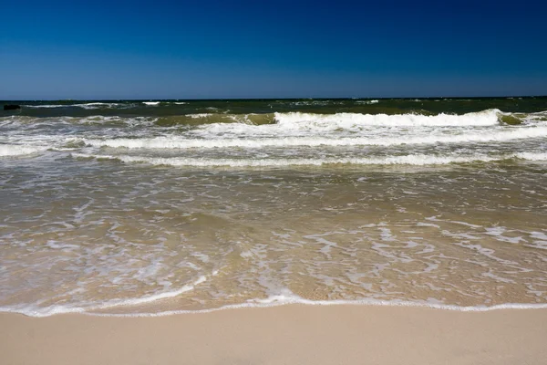 Zandstrand en golven op zee — Stockfoto