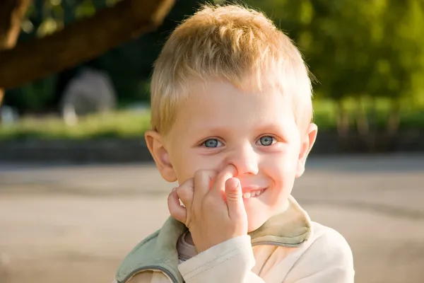 Chico cogiendo su nariz al aire libre —  Fotos de Stock