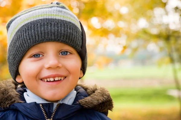 Boy smiling in autumn scenery — Stock Photo, Image