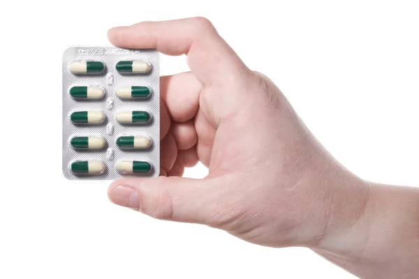 Рука, зеленые таблетки — стоковое фото