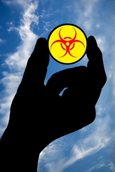 Hand met biohazard symbool en hemel — Stockfoto