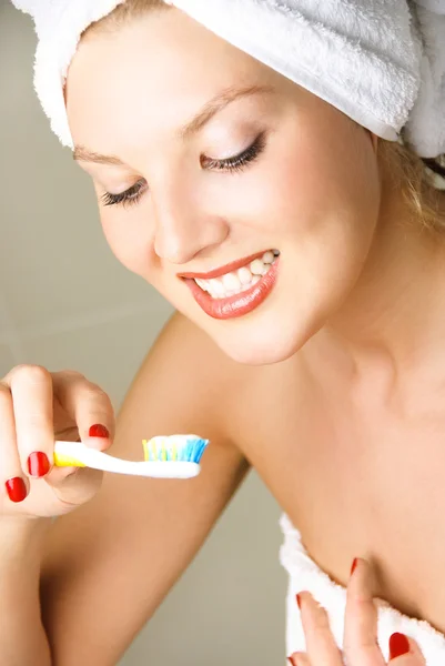 Mladá žena čistí zuby — Stock fotografie