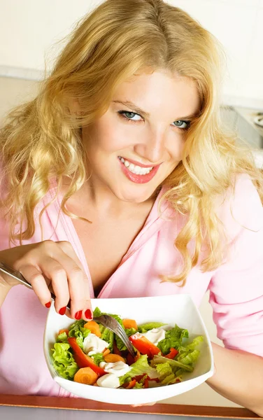 Mooie vrouw eten van een salade Stockafbeelding