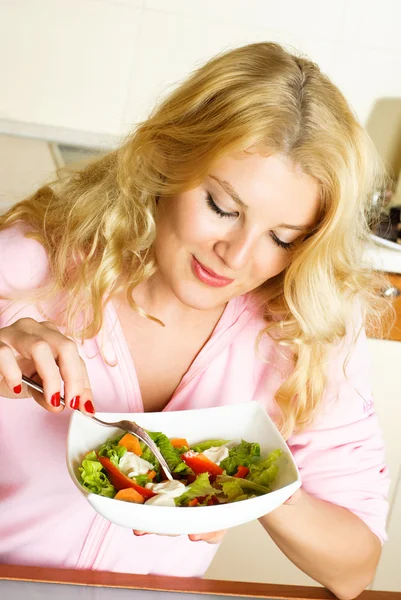 Frau isst Salat lizenzfreie Stockbilder