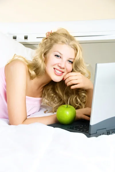 Chica bonita con un ordenador portátil Imágenes de stock libres de derechos