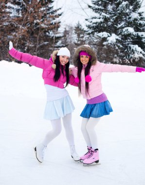 Two girls ice skating clipart