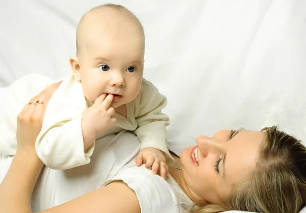 Mãe no sofá branco com seu bebê — Fotografia de Stock