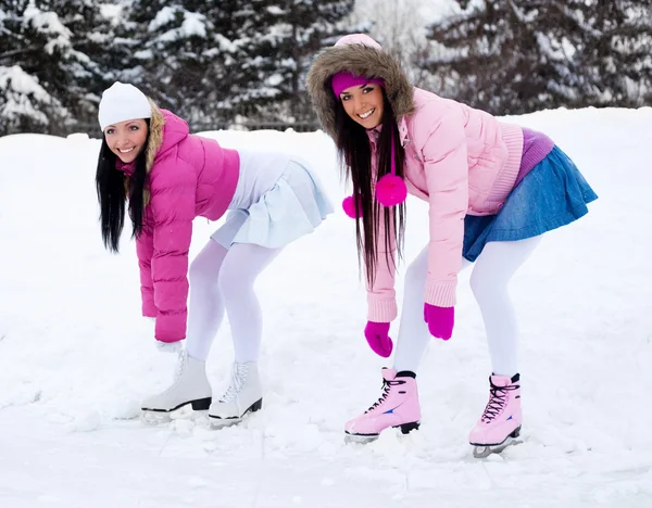 Две девушки катаются на коньках Стоковое Фото
