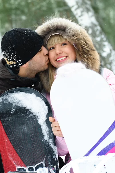 Feliz pareja con tablas de snowboard —  Fotos de Stock