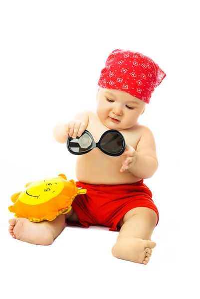 Cute baby putting on sunglasses — Stock Photo, Image