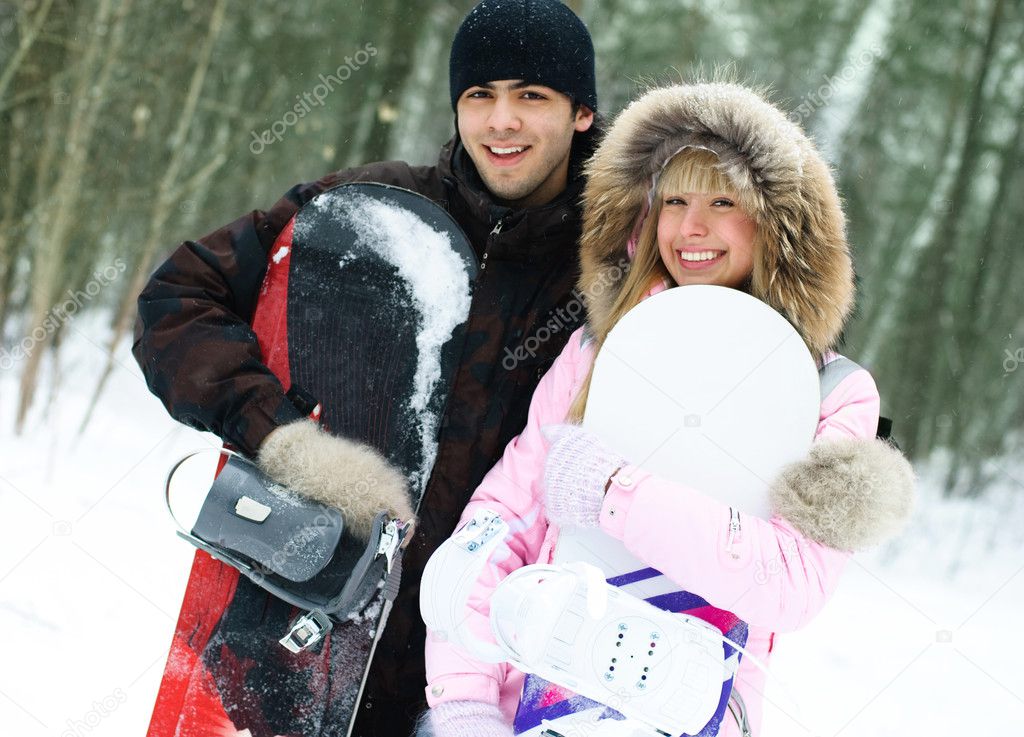 Happy couple with snowboards