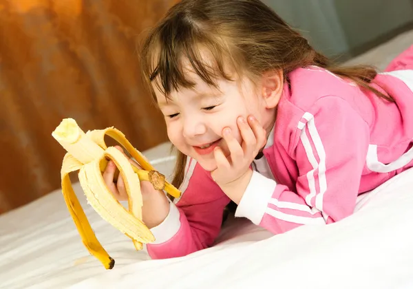바나나를 먹고 어린 소녀 — Stock Fotó