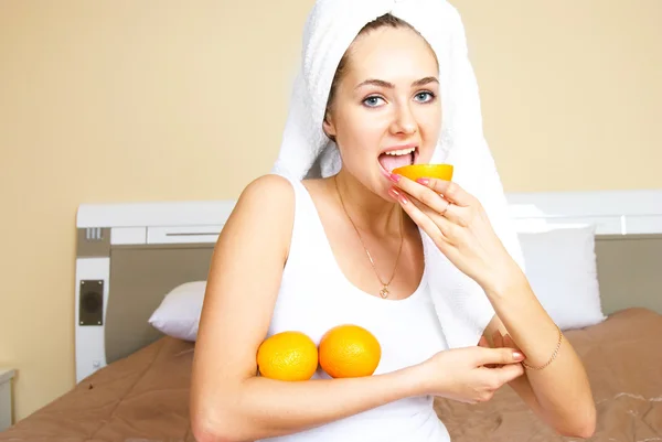 Девушка ест апельсины — стоковое фото